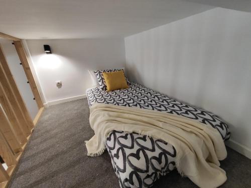 马德里Precioso apartamento en Puente Vallecas, Madrid. D的卧室配有一张黑色和白色的床,配有黄色枕头
