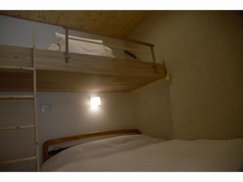 奈良鹿苑山庄山林小屋的小房间设有一张床和一张双层床