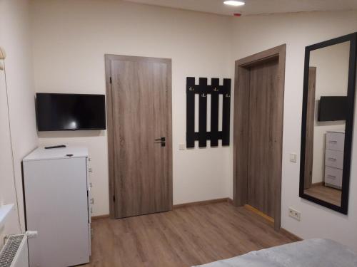 米库利钦Шале АНСО的一间设有两个木门和电视的房间