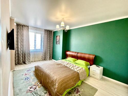 巴甫洛达尔4х комнатные апартаменты的绿色卧室,配有床和绿色的墙壁
