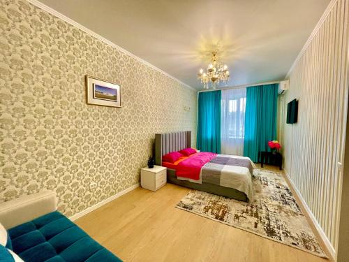 巴甫洛达尔1 комнатные апартаменты的一间卧室配有一张床和一张蓝色的沙发