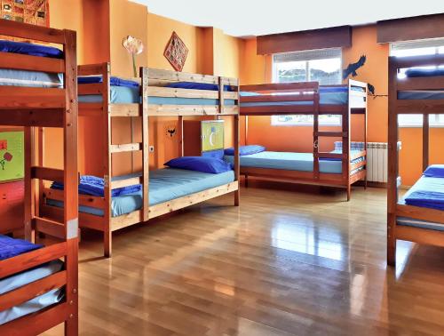 圣地亚哥－德孔波斯特拉Meiga Backpackers Hostel的一间客房内设有四张双层床的房间