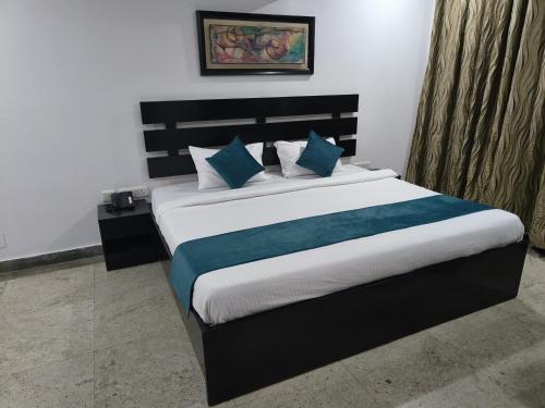 古尔冈CABANA REGENCY的一间卧室配有一张带蓝色枕头的大床