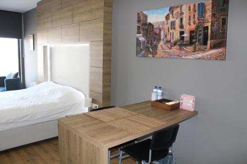 科贾埃利5 yıldızlı Dedeman’da özel residence dairesi的一间卧室配有一张床和一张木桌及椅子