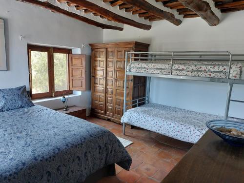 布维翁Casa de Alguaztar的一间卧室设有两张双层床和一张桌子