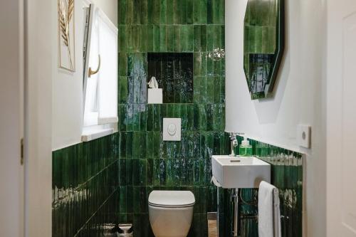 维罗纳HomeThirtyFour的绿色瓷砖浴室设有卫生间和水槽
