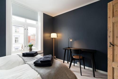特隆赫姆Home away from home in Trondheim的一间卧室配有一张带桌子和椅子的床