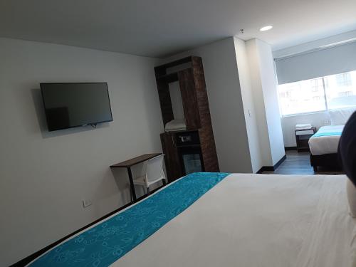 波哥大HOTEL AMERICAN VISA CORPORATE的配有一张床和一台平面电视的酒店客房