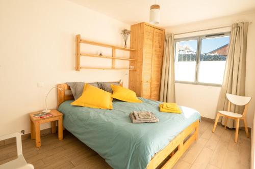 韦尔科尔地区朗Gite Le Rucher的一间卧室配有一张带黄色枕头的床和一扇窗户