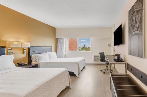 瓜达拉哈拉瓜达拉哈拉博览会嘉年华酒店的酒店客房配有两张床和一张书桌
