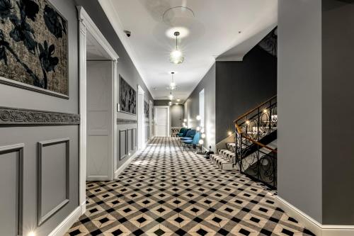 佩奇Palatinus Boutique Hotel的走廊上设有黑白格子地板