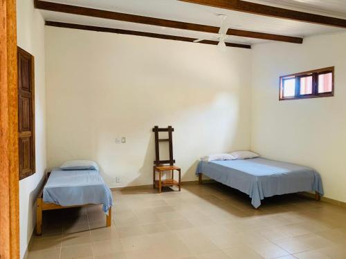 新维索萨Pousada Sem Stress Porto Itália的一间设有两张床和一张桌子的房间