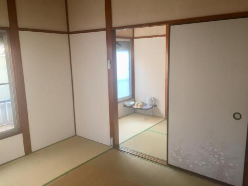 东京D-pdal Inn - Vacation STAY 39054v的一间空房间,设有玻璃门和桌子