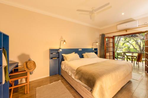马翁Sedia Riverside Hotel的一间卧室配有一张床、一张桌子和一个窗户。