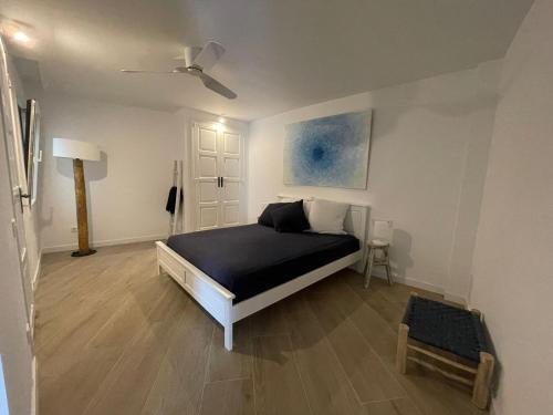 巴古尔Cap Sa Sal suites -Apartament Begur - Costa Brava的一间卧室配有一张床和吊扇