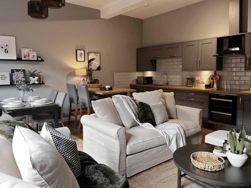 托德莫登Modern Ground Floor Apartment的一间带白色沙发的客厅和一间厨房