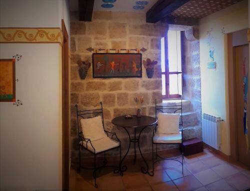 Baños de Rioja托雷富尔特S.XIII中世纪乡村旅馆的石墙房间内的小桌子和椅子