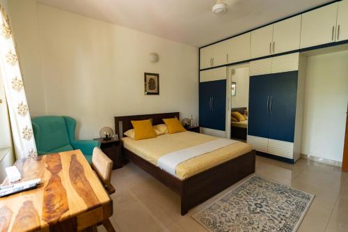 班加罗尔Luho 206的一间卧室配有一张床、一张桌子和蓝色橱柜。