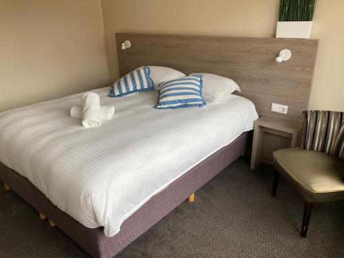 斯海弗宁恩Fisherman's House by Hofstad Hotels的卧室配有带枕头和椅子的大床