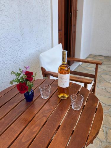 马拉松坎博斯Gaia Apartments,By Villa Kokkoni的木桌旁的一瓶威士忌