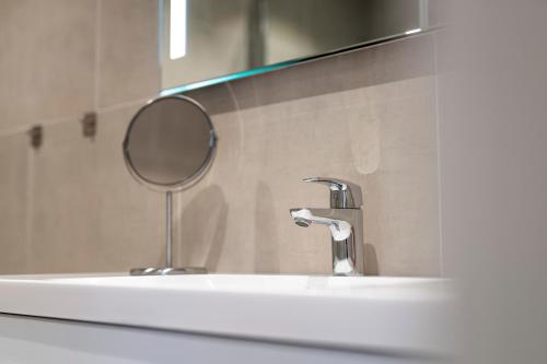 艾于兰Skaimsberg Holiday Apartments的浴室水槽设有镜子和水龙头