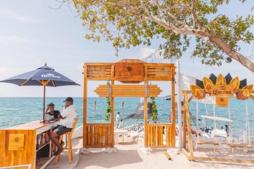 格兰德岛Bora Bora Beach Club & Hotel的两人坐在海滩上的桌子上