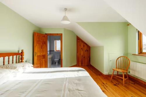 韦斯特波特Yellow House的卧室配有一张白色大床和一把椅子