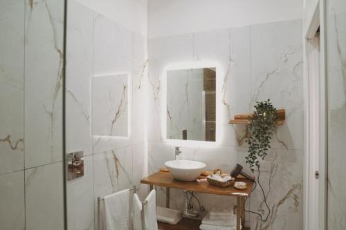 波蒂奇Sisina Luxury Room Jacuzzi & Piscina的一间带水槽和镜子的浴室