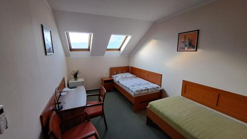 俄斯特拉发埃达奥斯特拉瓦高级旅馆的小房间设有两张床、一张桌子和椅子