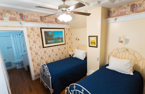 芒特多拉The Heirloom Inn的一间卧室配有两张床和吊扇
