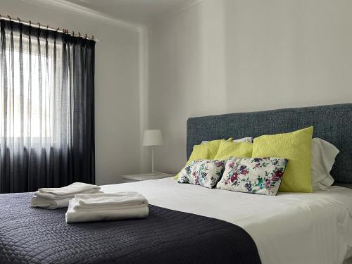 辛特拉Cozy Green Apartment的一间卧室配有一张床,上面有两条毛巾