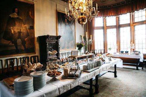 韦克舍特里博格斯洛特酒店的用餐室配有带盘子和食品的长桌