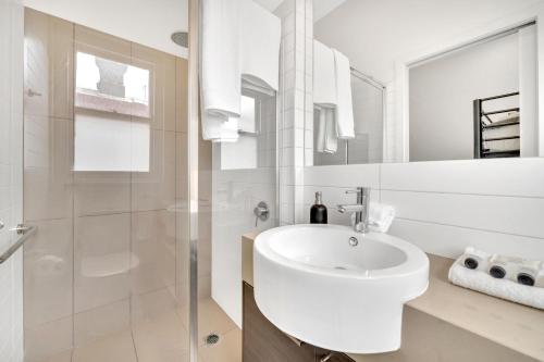 墨尔本Grosvenor 3121 Richmond的白色的浴室设有水槽和淋浴。