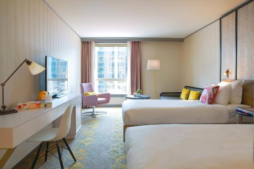 皮托巴黎拉德芳斯万丽酒店的酒店客房配有两张床和一张书桌