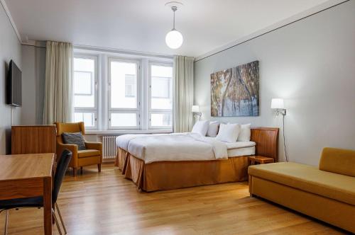 赫尔辛基赫尔辛基亚历山大丽笙酒店的酒店客房带一张床、一张桌子和椅子
