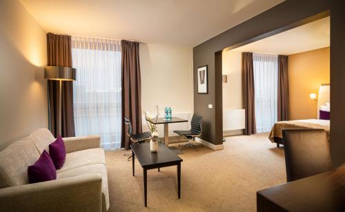 慕尼黑慕尼黑瑞拉诺酒店的酒店客房设有沙发和桌子