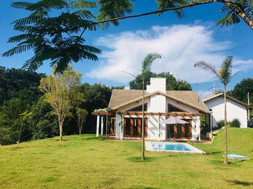 JaguariaívaCasa de campo com piscina的庭院中带游泳池的房子