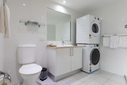 阿格奈什沃特艾格尼丝水滩俱乐部公寓的白色的浴室设有卫生间和洗衣机。