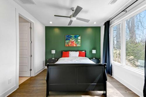 纳什维尔Nashville Vibe/3 Miles 2BroadWay/11 bds的一间卧室设有一张黑色的床和绿色的墙壁