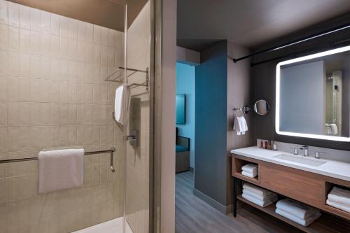 奥斯汀Austin Marriott Downtown的浴室配有盥洗盆和带镜子的淋浴