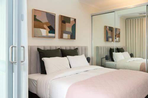 KeswickHilton Executive Apartments的一间卧室配有两张床和镜子