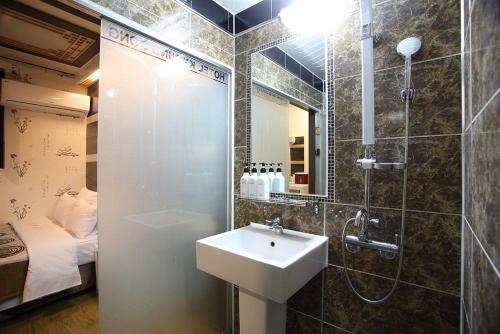 首尔明洞京东酒店的一间带水槽和淋浴的浴室