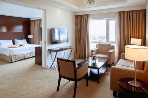 宿务Harolds Evotel Cebu的酒店客房设有床和客厅。