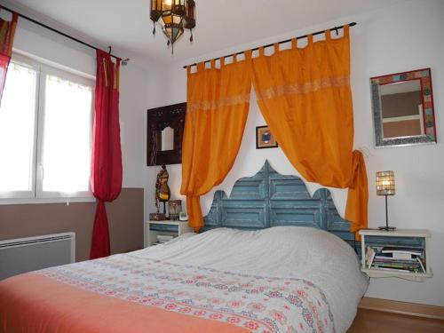 卡布勒通Maison Capbreton, 4 pièces, 6 personnes - FR-1-413-86的一间卧室配有带橙色窗帘的大床