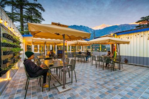 麦罗肯机The Hosteller Mcleodganj, Mall Road的坐在庭院桌子上的人