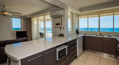 黄金海岸Viscount on the Beach的厨房配有大型白色台面和一些窗户