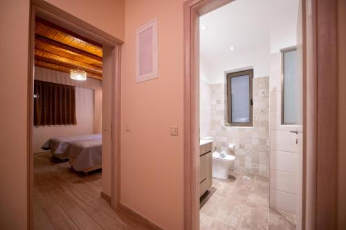 斯陶帕Villas Chrysanthi的一间卧室配有一张床,浴室设有卫生间
