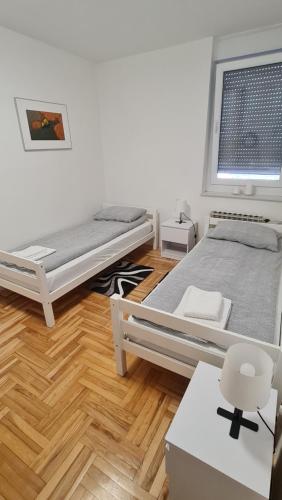 奥西耶克South 2 Osijek的一间卧室设有两张床,铺有木地板