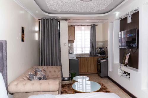 Langata RongaiSpringStone Studio Apartment Rm 19的客厅配有沙发和桌子
