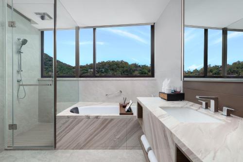 三亚三亚山海天雅诗阁服务公寓的一间带浴缸和淋浴的浴室,配有窗户
